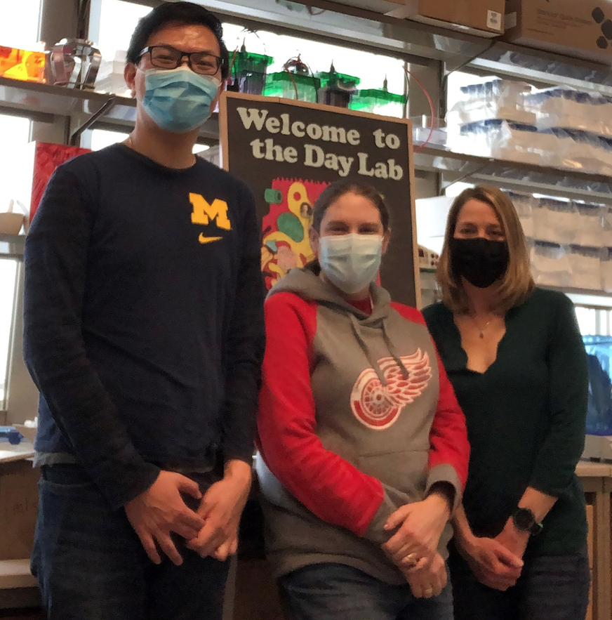 a group of three people standing together in the Day lab.